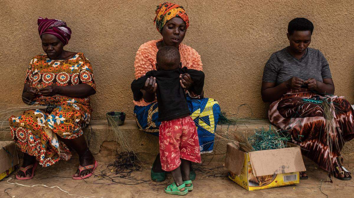Las mujeres tejen canastas dentro de una aldea de reconciliación el 6 de abril de 2019 en Mbyo, Ruanda. Los pueblos son el hogar de ex perpetradores y víctimas del genocidio en 1994 que viven en paz juntos.