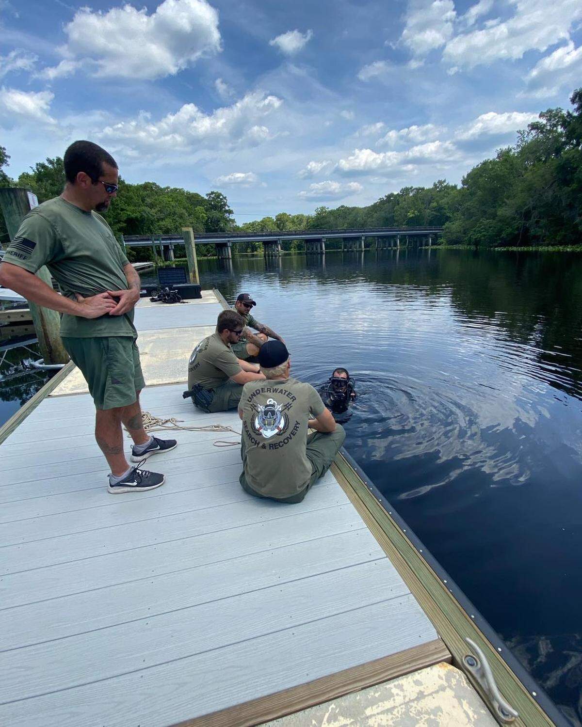 Miembros del equipo del buceo Departamento de Policía de de St. Johns County, Florida, observan el procedimiento para recuperar un reloj de $16,00 de un arroyo el miércoles 22 de junio de 2022.