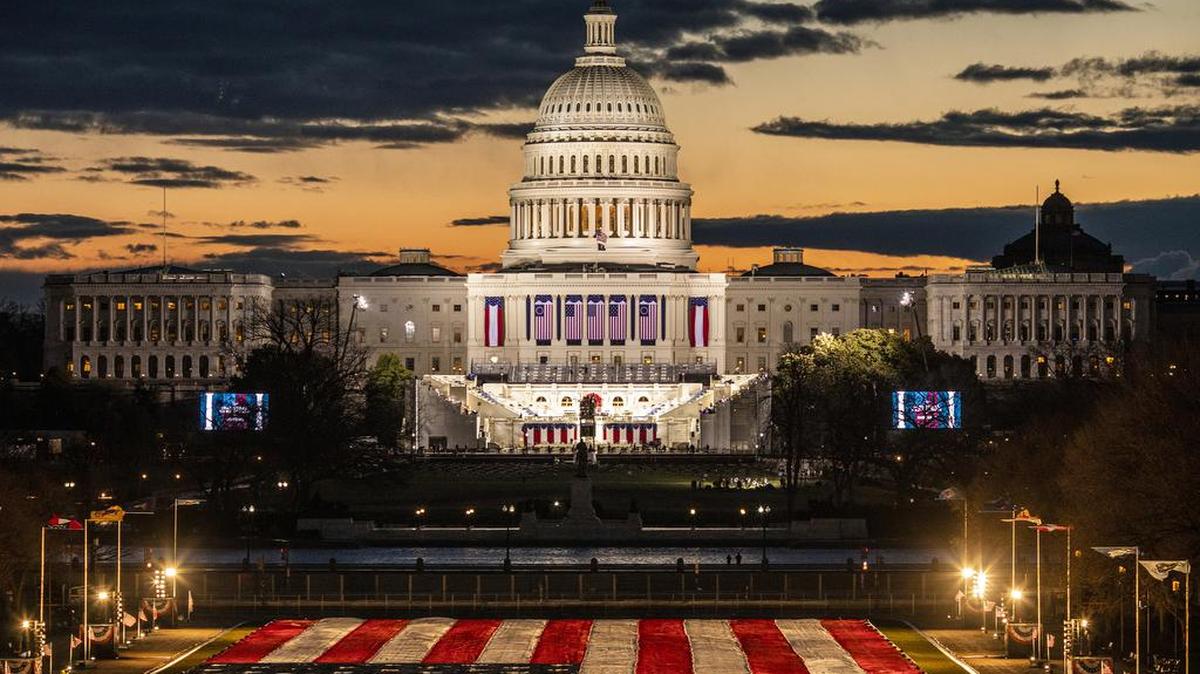 A giant U.S. flag is stretched out on the National Mall as dawn breaks over Washington on Wednesday morning, Jan. 20, 2021, hours before the presidential inauguration of Joe Biden. For many in an exhausted, divided nation, the inauguration was a sea change, not just a transition. 