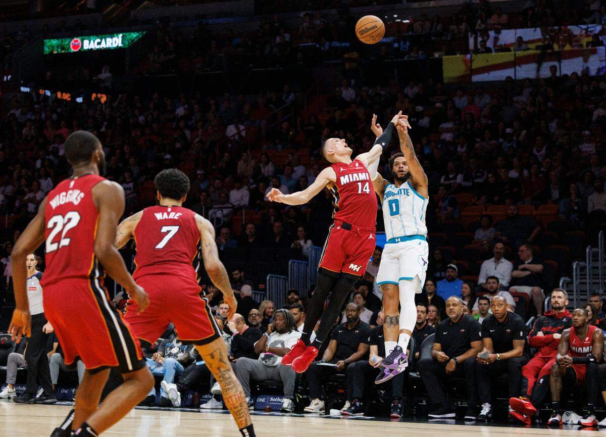 El jugador del Heat Tyler Herro (14) trata de bloquear el tiro de Miles Bridges (0), de los Hornets de Charlotte, en el partido celebrado el 10 de marzo de 2025 en Miami.