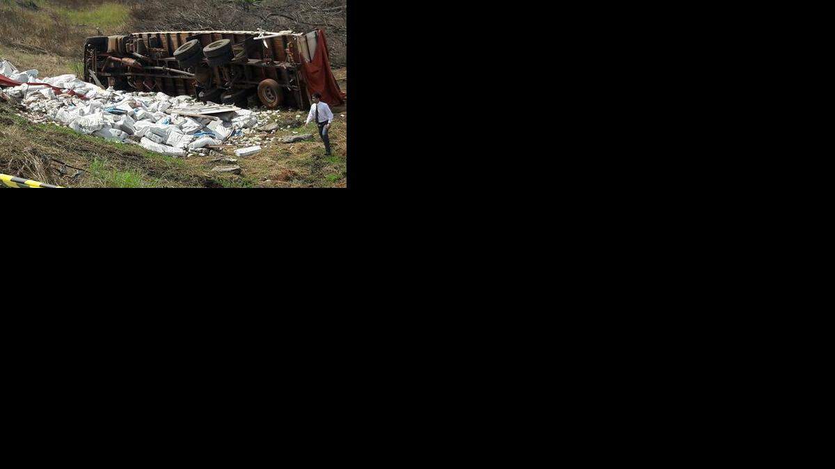 Un hombre camina junto a unas 30 toneladas de billetes venezolanos que cayeron de un camión volcado cerca de San Estanislao, 220 kilómetros al norte de Asunción, el miércoles 15 de febrero de 2017. 