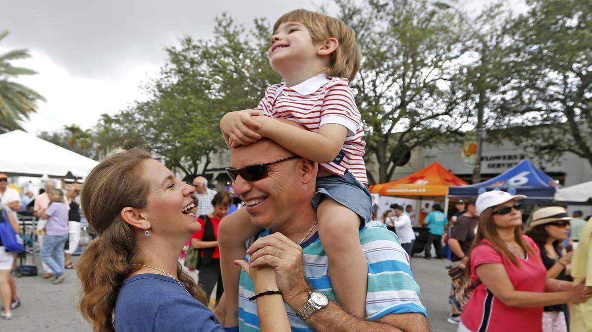 Patricia y Jorge Gutiérrez bailan mientras su hijo Jonathan disfruta del paseo en el  Carnaval on the Mile en Coral Gables el 7 de marzo de 2015.