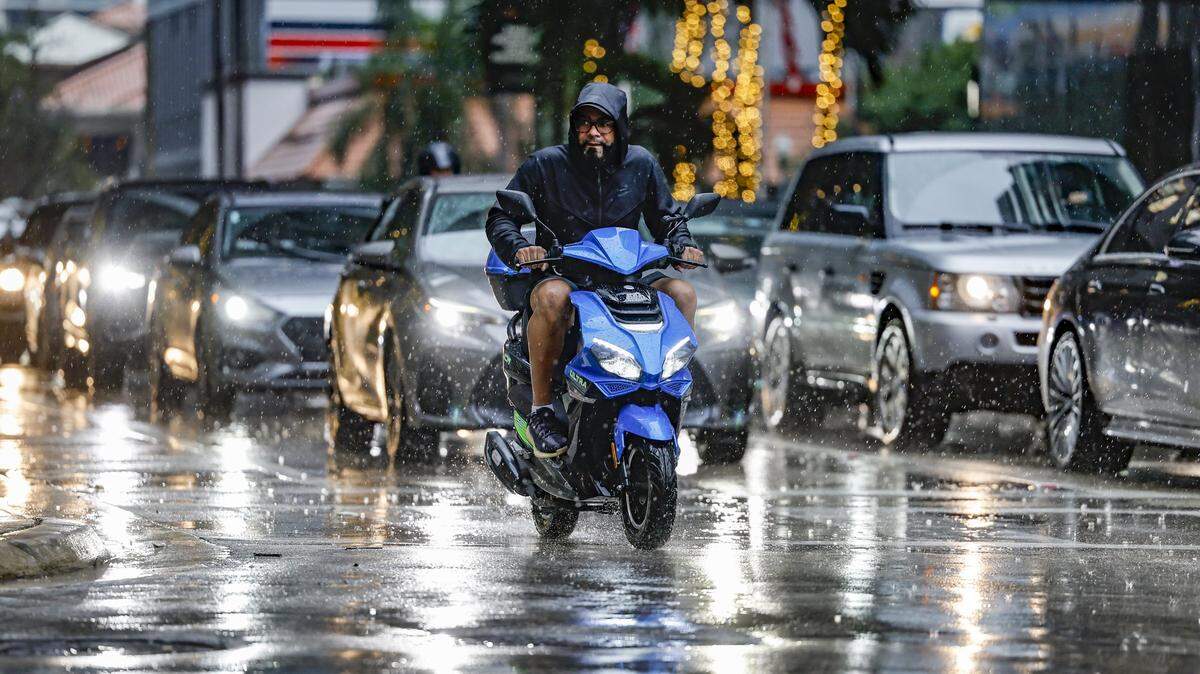 Un motociclista esquiva la lluvia mientras cruza la intersección de South Miami Avenue y 8th Street en Miami el miércoles 15 de noviembre de 2023.
