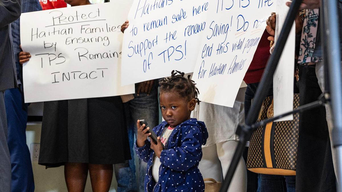 Jenny Bellus, de 22 meses, asiste con su madre Rose Myrlene Elmond, beneficiaria del TPS, a una conferencia de prensa convocada por el Movimiento Family Action Network para discutir la revocación del TPS de Haití por parte de la administración del presidente Trump, que afecta a miles de familias haitianas, el viernes 21 de febrero de 2025.