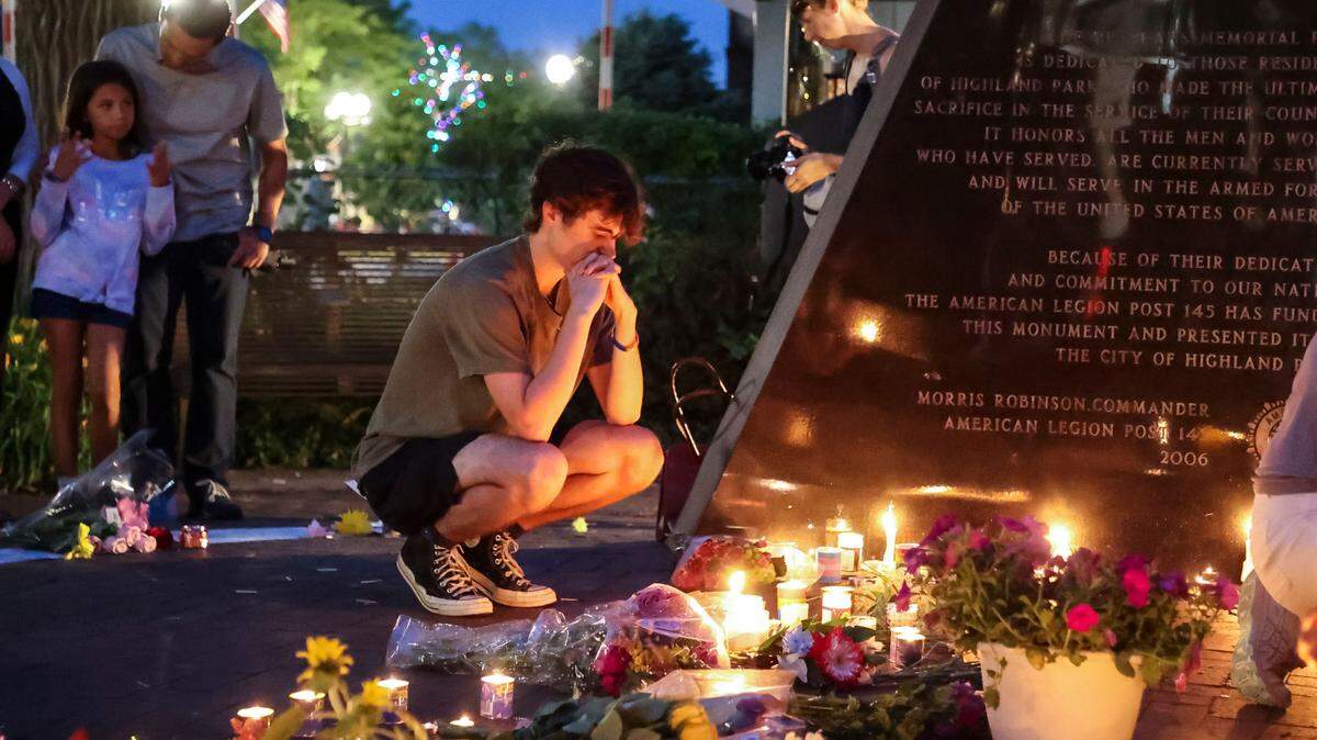 Un hombre reza frente a un memorial creado en homenaje a las víctimas del tiroteo de Highland Park, un suburbio de Chicago, el 6 de julio de 2022. El tiroteo fue el 4 de julio y siete personas murieron.