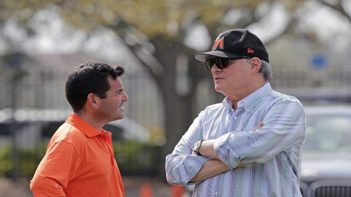 El dueño de los Marlins Jeffrey Loria (der.) habla con el presidente del equipo David Samson, en el primer día del entrenamiento de la pretemporada, el 14 de febrero del 2017 en Jupiter, Florida.