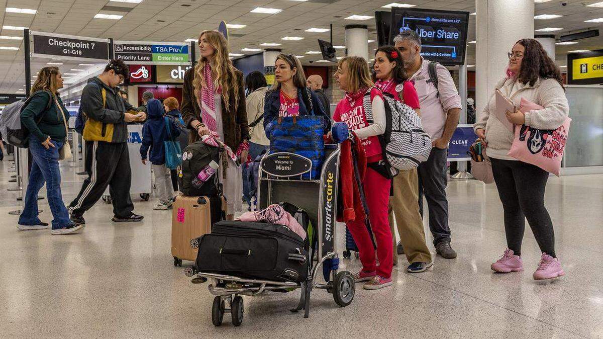 Activistas de un grupo de 140 personas se dirigen al punto de control antes de partir del Aeropuerto Internacional de Miami hacia La Habana, como parte del convoy internacional Nuestra América, para entregar ayuda humanitaria a Cuba y protestar contra las políticas estadounidenses, el viernes 20 de marzo de 2026.