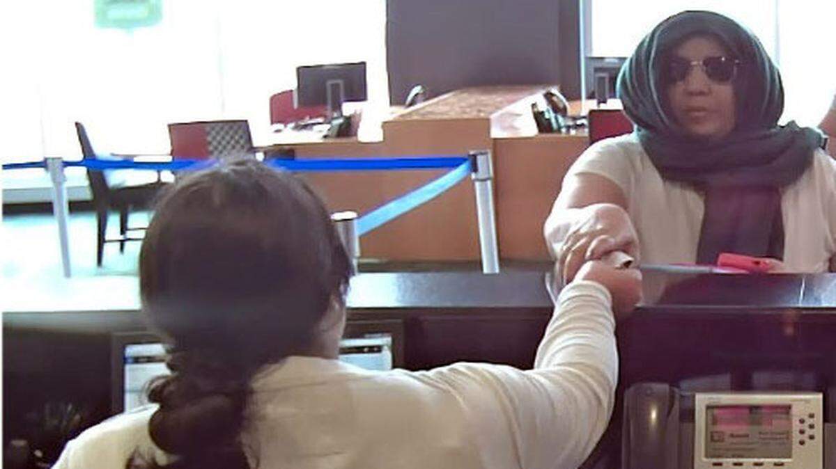 En un video de vigilancia se puede apreciar el momento en que la mujer, que llevaba puesto una bufanda verde y gafas de sol para esconder su identidad, le entrega a una cajera una nota donde le pide que le dé dinero.