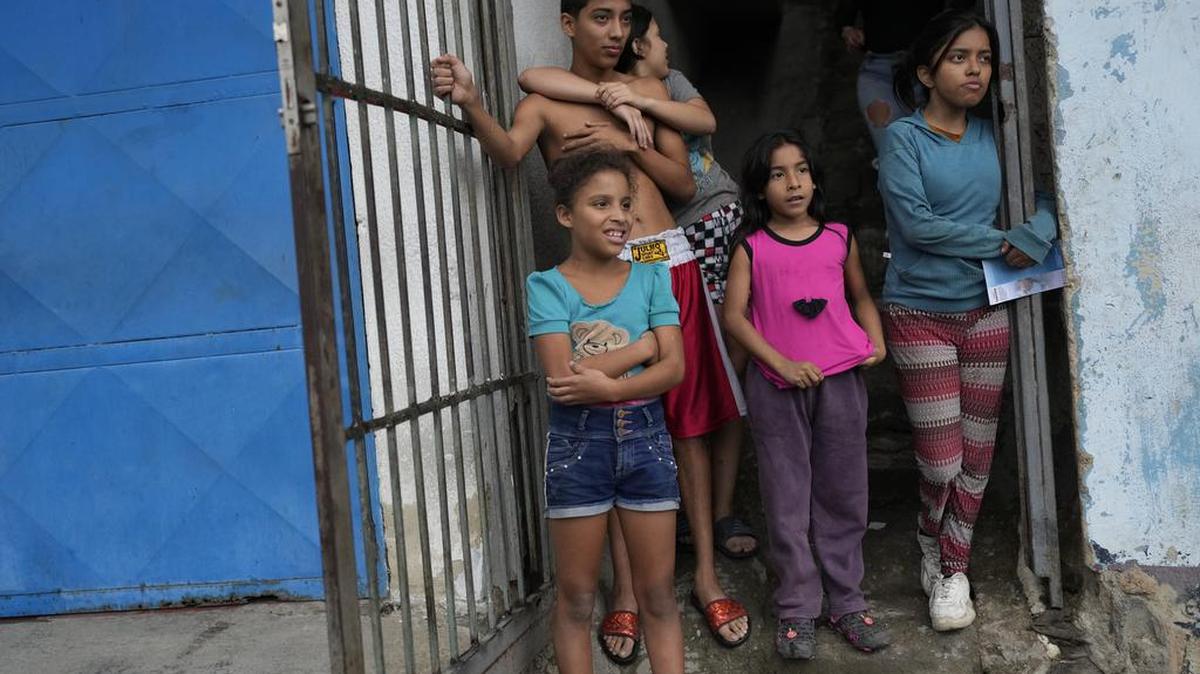 Residentes del barrio Carapita se paran en la entrada de su casa mientras observan a Tomás Guanipa, candidato a la alcaldía de la Mesa de Unidad Democrática (MUD) por el municipio Libertador, pasar saludando a los simpatizantes en Caracas, Venezuela, el martes 26 de octubre de 2021. Las elecciones regionales serán se llevará a cabo el 21 de noviembre (AP Photo / Ariana Cubillos)
