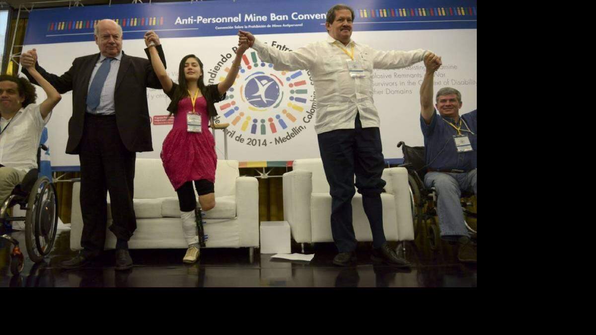 El Secretario General de la Organización de Estados Americanos (OEA), José Miguel Insulza (2-i), el vicepresidente de Colombia, Angelino Garzón (2-d) y la colombiana Ángela Ruales - víctima de una mina antipersonal - con los pantalones enrollados , participan en una actividad del programa "Dona tu pierna" la conciencia y la solidaridad (conocido como "Remangate" en español), durante una conferencia mundial sobre ayuda para las víctimas de guerra y sobrevivientes de minas antipersonales y otros restos explosivos en Medellín, departamento de Antioquia, Colombia, el 4 de abril de 2014. De acuerdo con las organizaciones gubernamentales y de derechos humanos, Colombia es el segundo país del mundo después de Afganistán, con el mayor número de víctimas de minas antipersonales.