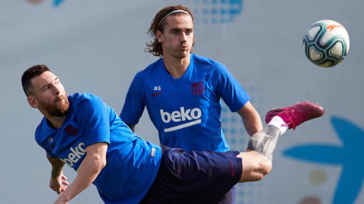 Los jugadores del Barcelona Leo Messi (izq.) y Antoine Griezmann durante el entrenamiento que el equipo azulgrana realizó este lunes 23 de septiembre de 2019 en la ciudad deportiva Joan Gamper en Barcelona.