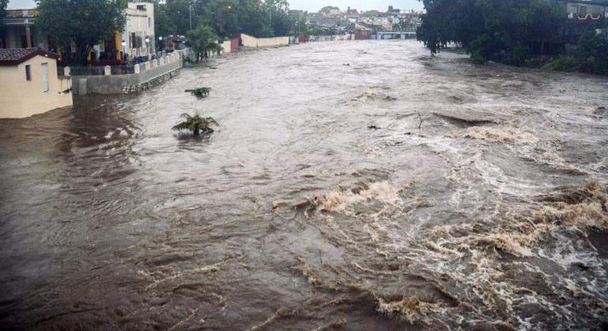 Esta imagen publicada por la Agencia Cubana de Noticias muestra un río desbordado por las fuertes lluvias asociadas a la tormenta subtropical Alberto, el 28 de mayo de 2018, en la provincia de Sancti Spiritus.