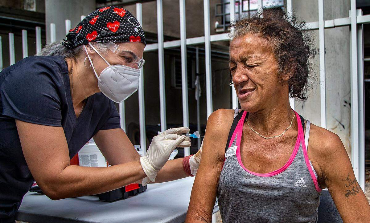 La enfermera Niurka Pérez vacuna contra el COVID-19 a Catherine Ortiz el viernes 21 de mayo de 2021. Ortiz es una mujer sin hogar que vive debajo de un paso subterráneo de la I-95 en el downtown de Miami. La División de Manejo de Emergencias llevará a cabo recorridos de vacunación en puntos de acceso y refugios para personas sin hogar en Miami-Dade para garantizar que tengan acceso a la vacuna.