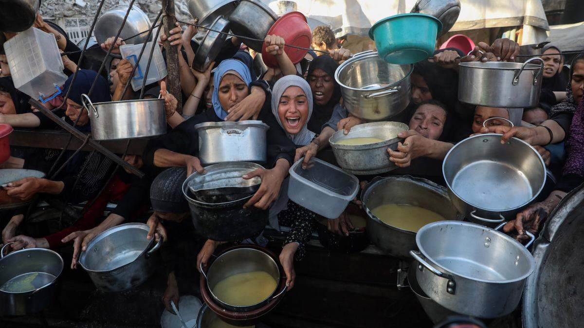 Palestinos desplazados esperan para recibir comida de un centro de distribución de ayuda humanitaria en Ciudad de Gaza, el lunes 14 de julio de 2025.