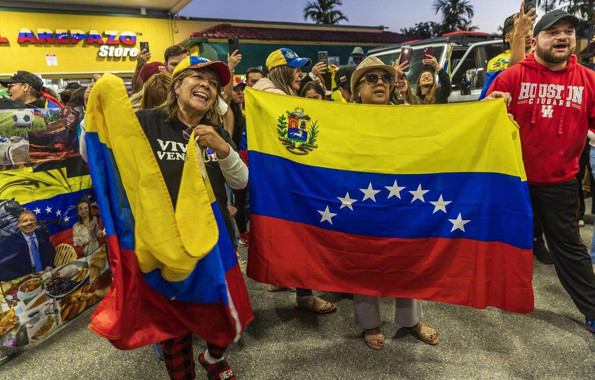 Esther Ojeda (izquierda) y Mirlene González se encontraban entre un grupo de venezolanos exiliados que viven en el sur de Florida celebrando frente a El Arepazo, en Doral, Florida, después de que Estados Unidos atacara Venezuela y capturara al líder venezolano Nicolás Maduro, el 3 de enero de 2026.