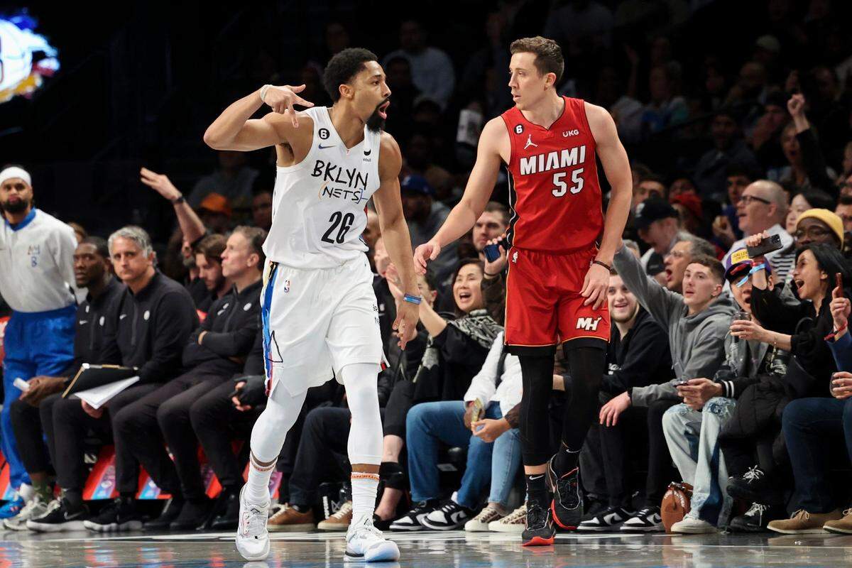 El escolta de los Nets Spencer Dinwiddie (26) celebra tras anotar un tiro de tres puntos mientras el jugador del Heat de Miami Duncan Robinson corre a su lado, en el partido celebrado el 15 de febrero de 2023 en New York.