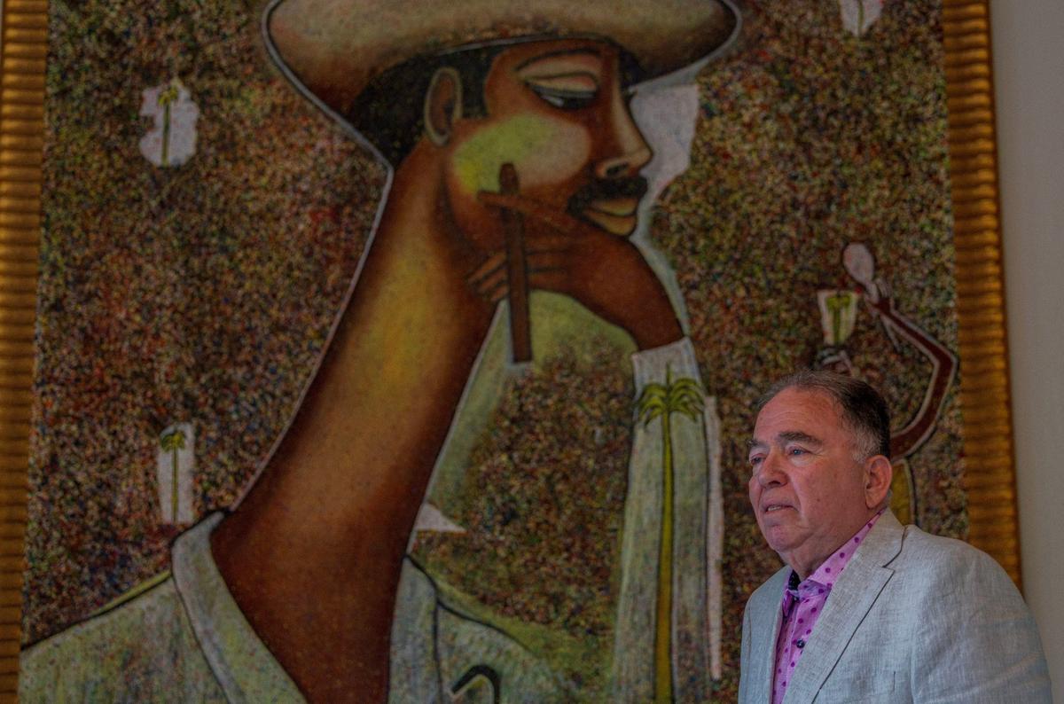 El productor Recaredo Gutiérrez, junto a un cuadro de Beny Moré pintado por Andrés Puig, en su casa de Miami. Recaredo produjo el documental ‘Al Bárbaro del Ritmo’, que se presenta el 23 de agosto en el Koubek Center, en homenaje a los 105 años del natalicio del Beny y como parte la serie de Cine Cubano del Miami Dade College.