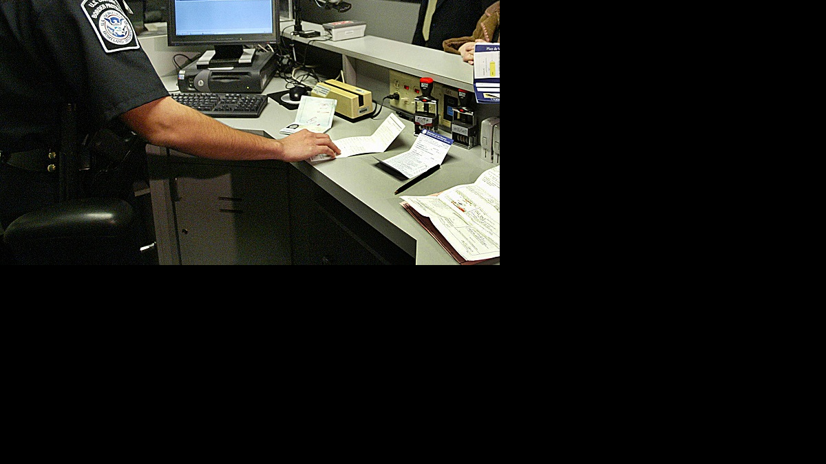 Un agente revisa la visa de un viajero en el Aeropuerto Internacional de Miami.