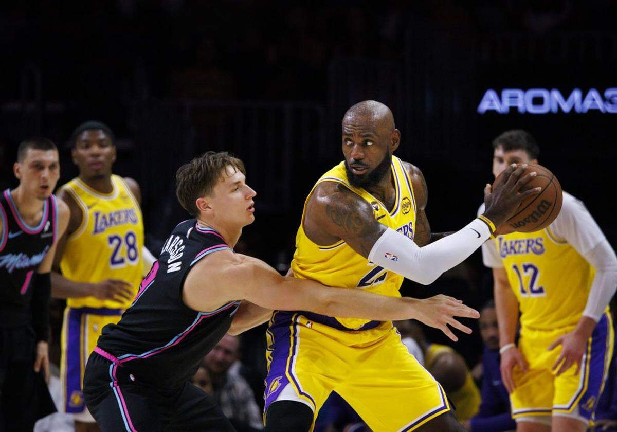 El astro de los Lakers de Los Angeles LeBron James trata de pasar la marca de Pelle Larsson, del Heat, en el partido celebrado el 19 de marzo de 2026 en Miami. 