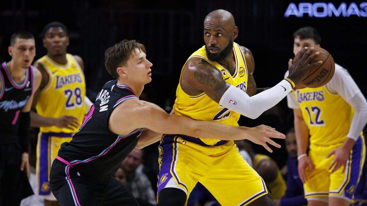 El astro de los Lakers de Los Angeles LeBron James trata de pasar la marca de Pelle Larsson, del Heat, en el partido celebrado el 19 de marzo de 2026 en Miami. 