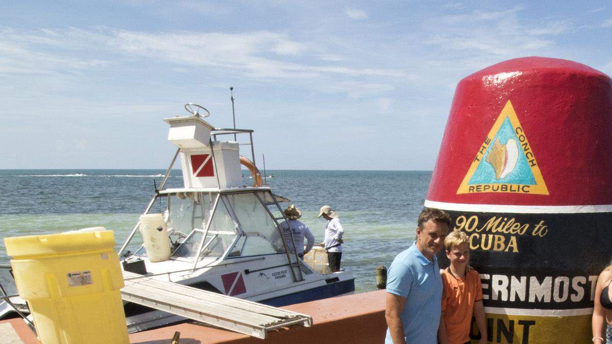Turistas posan el miércoles 13 de julio con el indicador que dice “90 millas a Cuba, punto más sur de Estados Unidos”, una de las atracciones turísticas más populares en Cayo Hueso, Florida. 