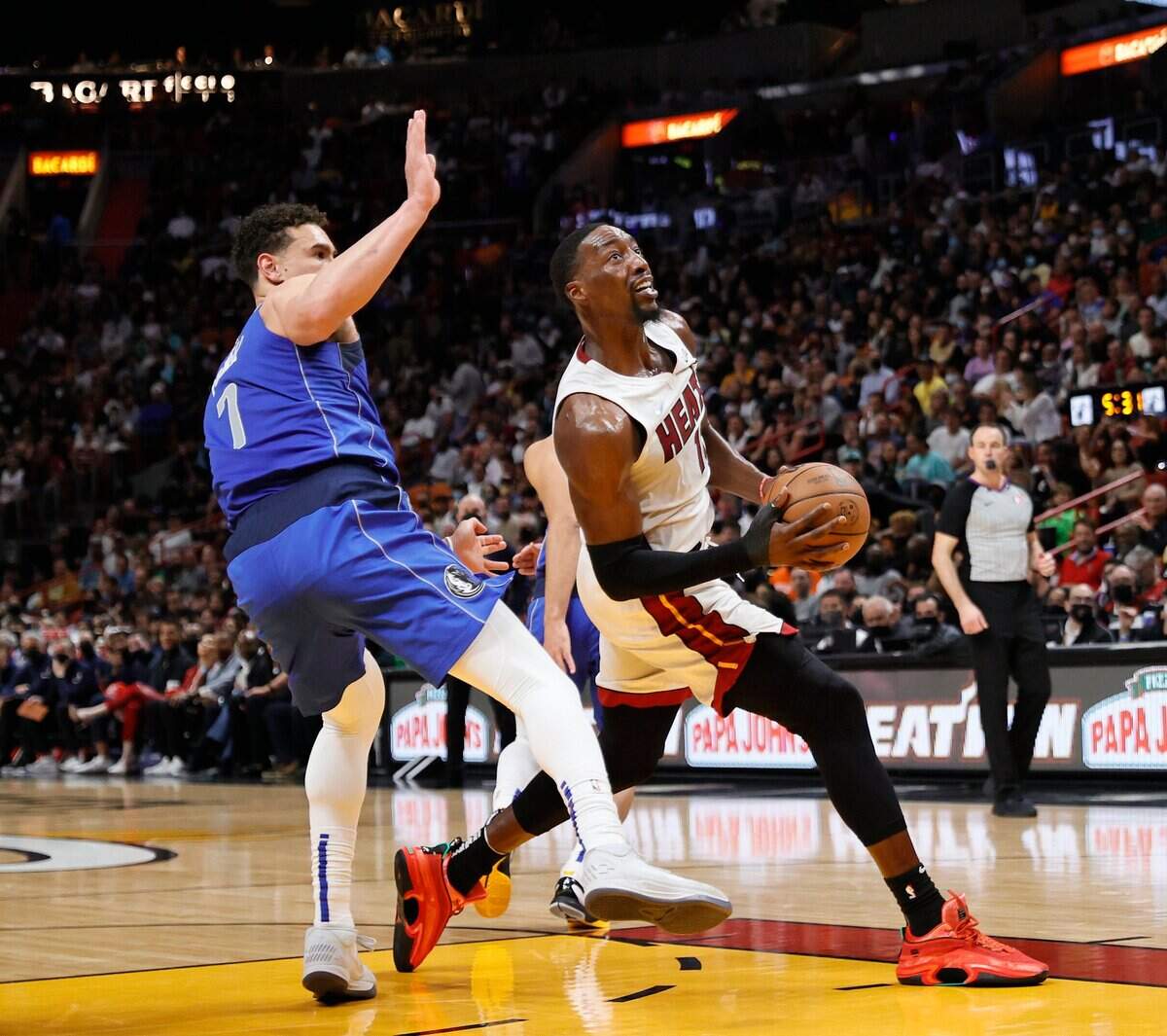 El jugador del Heat Bam Adebayo entra al aro ante la marca de Dwight Powell, de los Mavericks de Dallas, en el partido celebrado el 15 de febrero de 2022 en Miami.