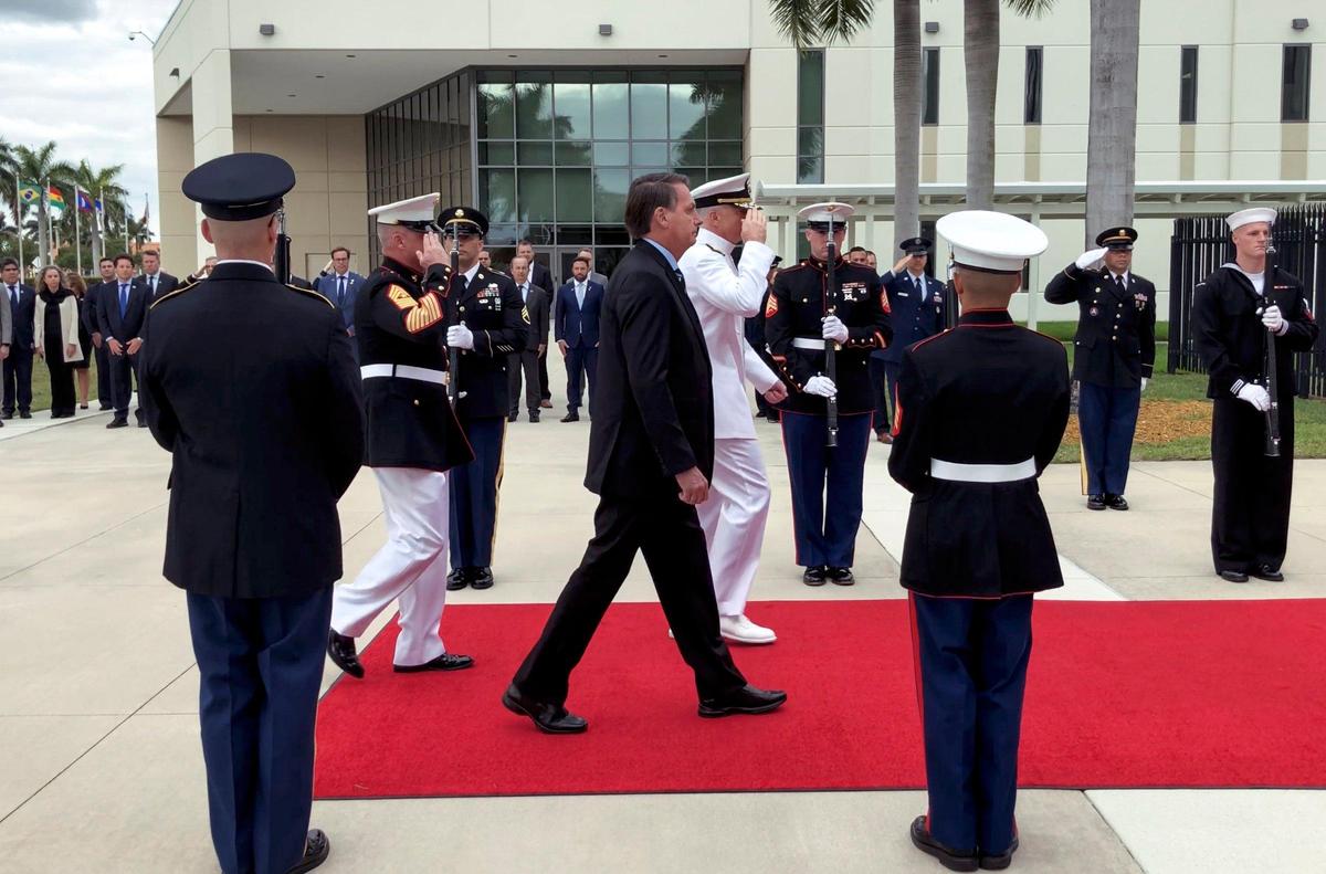 El presidente de Brasil, Jair Bolsonaro, en el centro, camina junto al almirante Craig Faller, durante su visita al Comando Sur de los Estados Unidos en Doral., el domingo 8 de marzo de 2020.