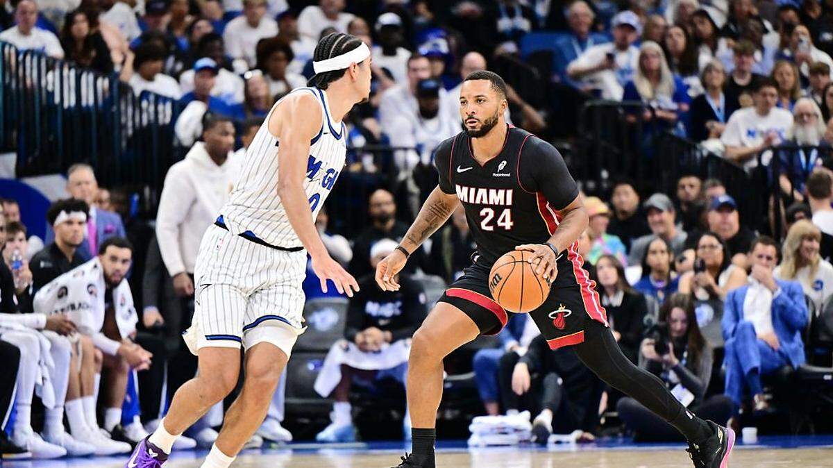 El jugador del Heat de Miami Norman Powell (der.) entra al aro ante la marca de Anthony Black, del Magic, en el partido de la NBA celebrado el 22 de octubre de 2025 en Orlando, Florida. 