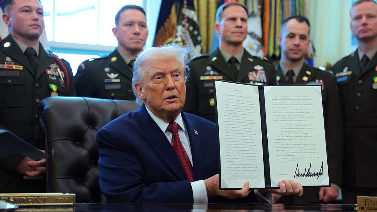 WASHINGTON, DC - DECEMBER 15: U.S. President Donald Trump poses with a recently signed executive order classifying fentanyl as a "weapon of mass destruction," during a ceremony for the presentation of the Mexican Border Defense Medal in the Oval Office of the White House on December 15, 2025 in Washington, DC. During the ceremony, Trump recognized the first 13 service members to receive the recently established Mexican Border Defense Medal (MBDM), which recognizes service members supporting Customs and Border Protection on the U.S.-Mexico border. (Photo by Anna Moneymaker/Getty Images)