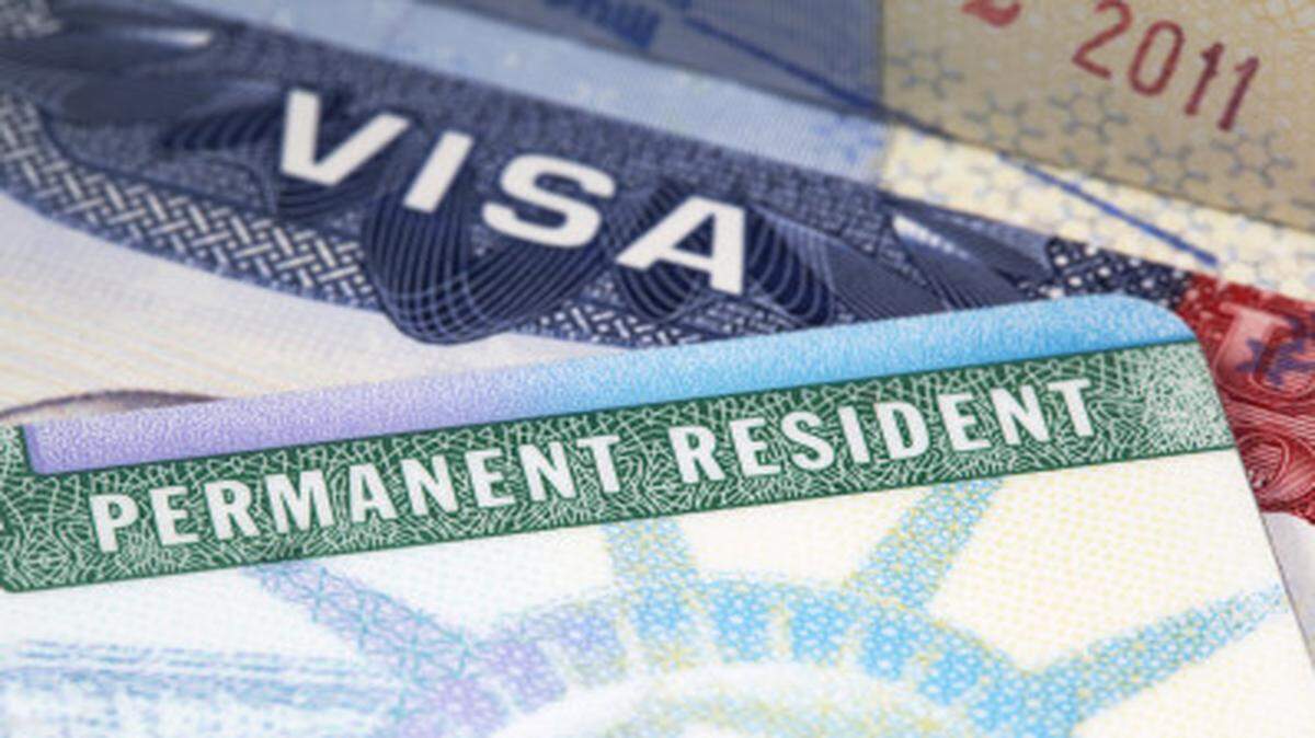 Una tarjeta de residencia permanente y una visa se pueden ver en esta foto de archivo. 