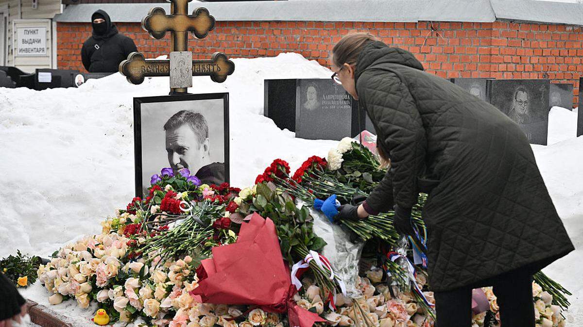 Una mujer deposita flores en la tumba del líder de la oposición rusa Alexei Navalny en el cementerio de Borisovo en Moscú, el lunes 16 de febrero de 2026, conmemorando el segundo aniversario de su muerte en una colonia del Ártico.