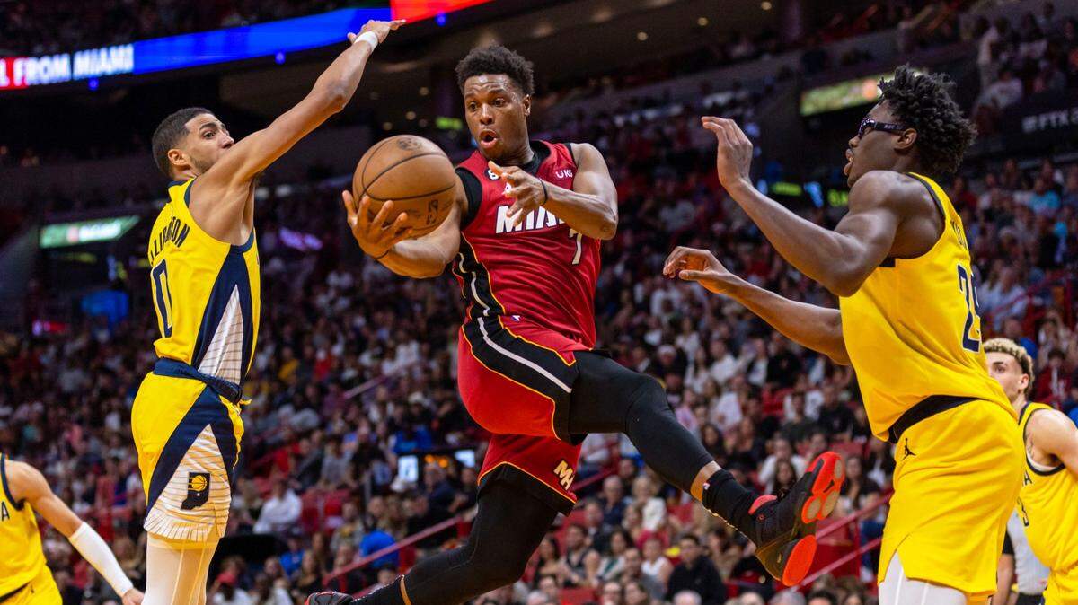 El armador de los Miami Heat, Kyle Lowry (7), pasa el balón mientras el guardia de los Indiana Pacers, Tyrese Haliburton (0), y el alero Jalen Smith (25), hacen doble equipo durante la primera mitad de un partido de la NBA en el FTX Arena en el centro de Miami, Florida, el viernes, 23 de diciembre de 2022.