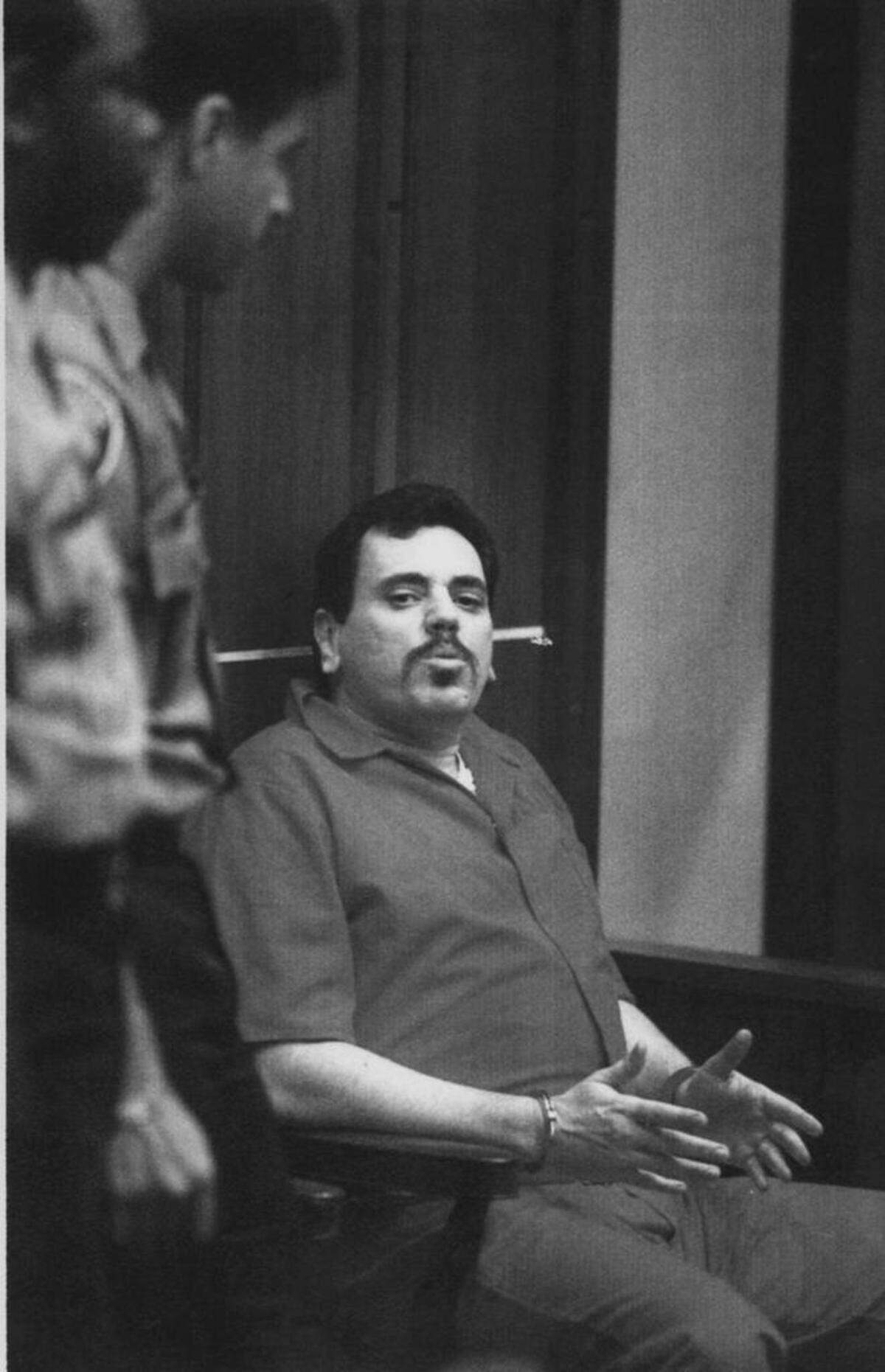 Benjamin Kramer, esposado, fue acusado de asesinar al constructor de lanchas rápidas Don Aronow. En esta foto del 1 de abril de 1993, se encontraba en el Edificio de Justicia Metropolitana de Miami. Kramer fue sentenciado a 19 años de cárcel y murió en Miami a los 60 años en 2009.