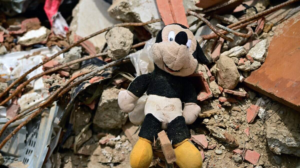 This image shows a plush Mickey Mouse amid rubble in the site of a collapsed building in Caraballeda, state of La Guaira, Venezuela, on July 10, 2026, following the June 24 twin earthquakes. The death toll from the powerful double earthquake has risen to at least 3,889, whilst the number of injured remains at almost 17,000, and nearly 18,000 people were left homeless according to the last official reports. (Photo by MARTIN BERNETTI / AFP via Getty Images)