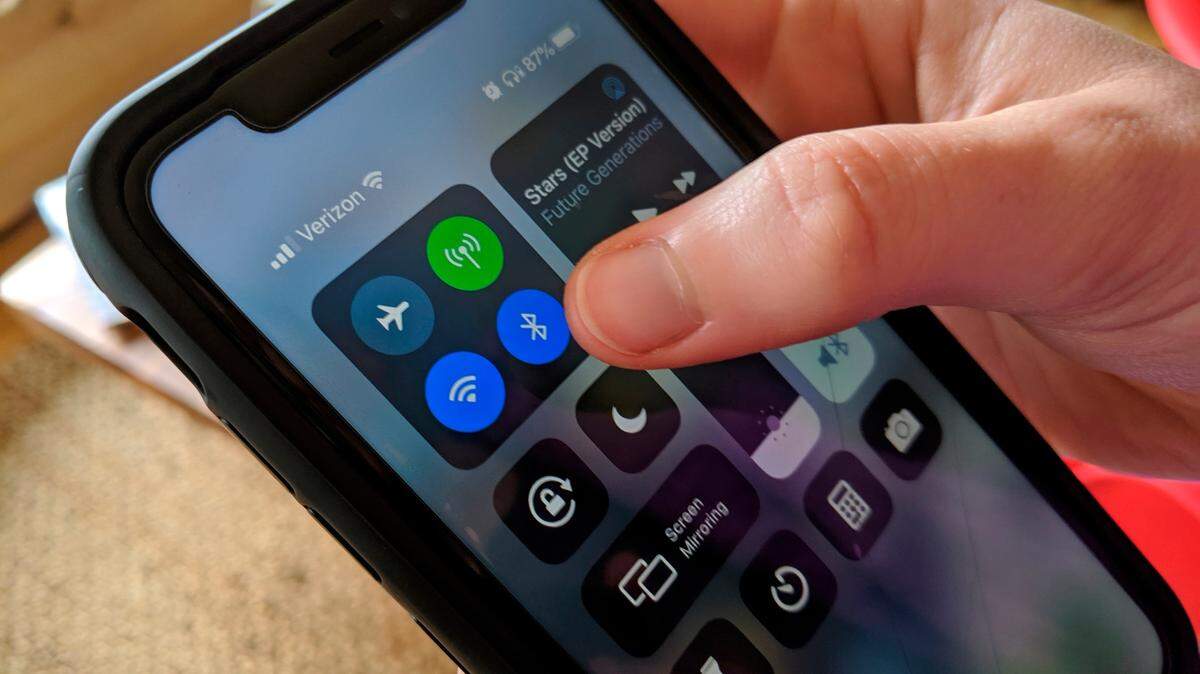 Una usuaria de iPhone activa la opción de Bluetooth en su teléfono. La tecnología se aplicó por primera vez en 2,000 en teléfonos móviles y computadoras de escritorio, y se extendió a impresoras y computadoras portátiles (laptops) en 2001.