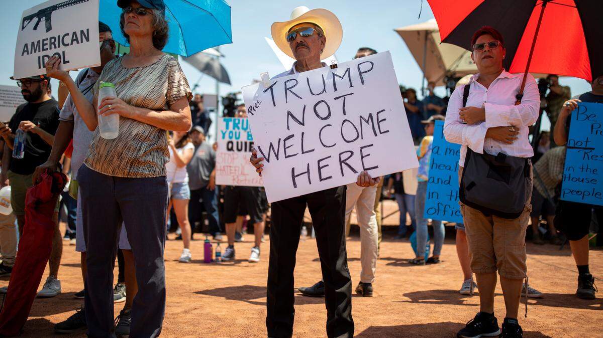 Miguel de Anda (centro) sostiene un cartel mientras acompaña a otros manifestantes opuestos a la visita del presidente Donald Trump a El Paso, Texas, durante una manifestación el 7 de agosto de 2019.