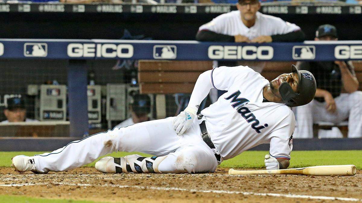 LEWIS BRINSON se retuerce de dolor tras ser golpeado por una pelota en un juego contra los Cachorros el 15 de abril.