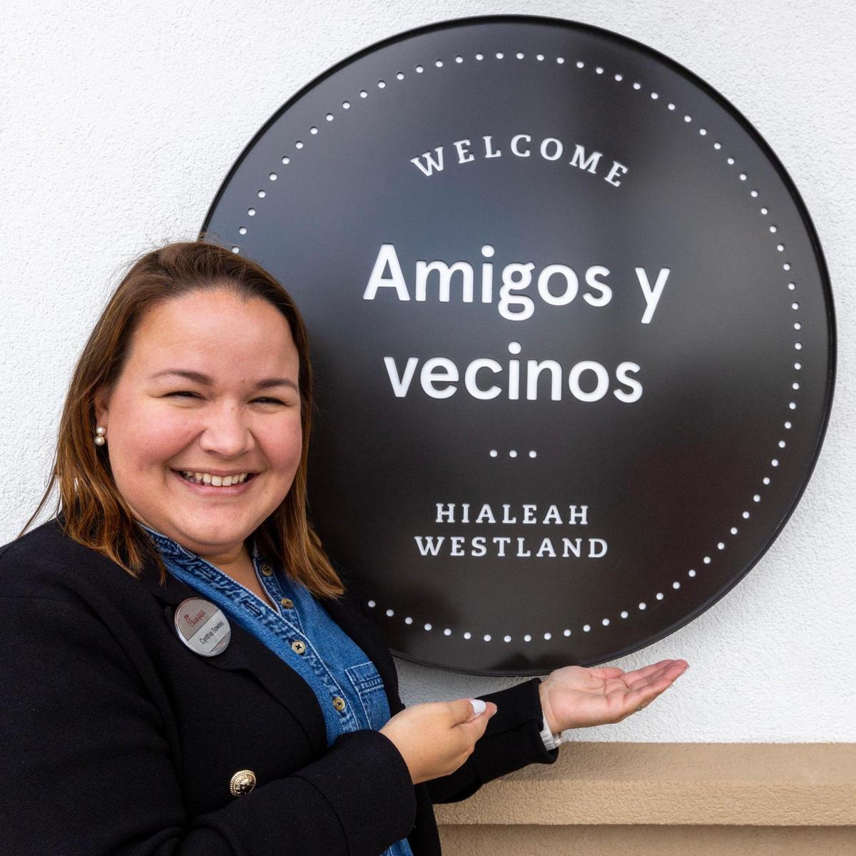 Cynthia Bowles shows one of the signs written in English and Spanish at her Chick-fil-A restaurant in Hialeah.