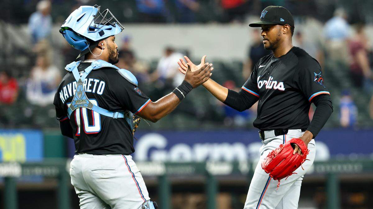 El relevista de los Marlins, George Soriano (der.), celebra con el receptor, Brian Navarreto, después del partido contra los Rangers de Texas, el viernes en el Globe Life Field de Texas.