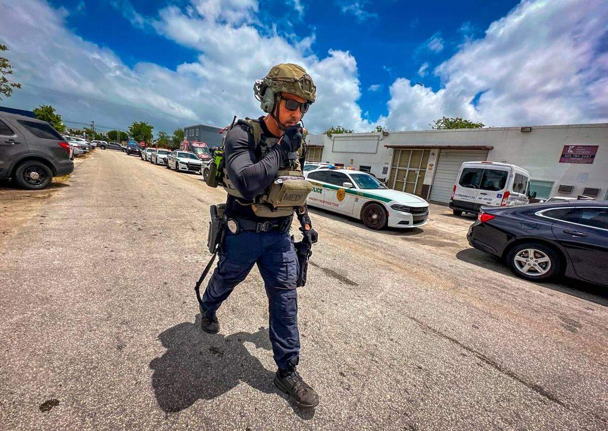 Miami, FL, 24 de abril de 2025 – Agentes del orden armados caminan por el lugar mientras la Oficina del Sheriff de Miami-Dade investiga un tiroteo cerca de la avenida Southwest 75 y la calle 45, en el distrito industrial al sur de Bird Road.