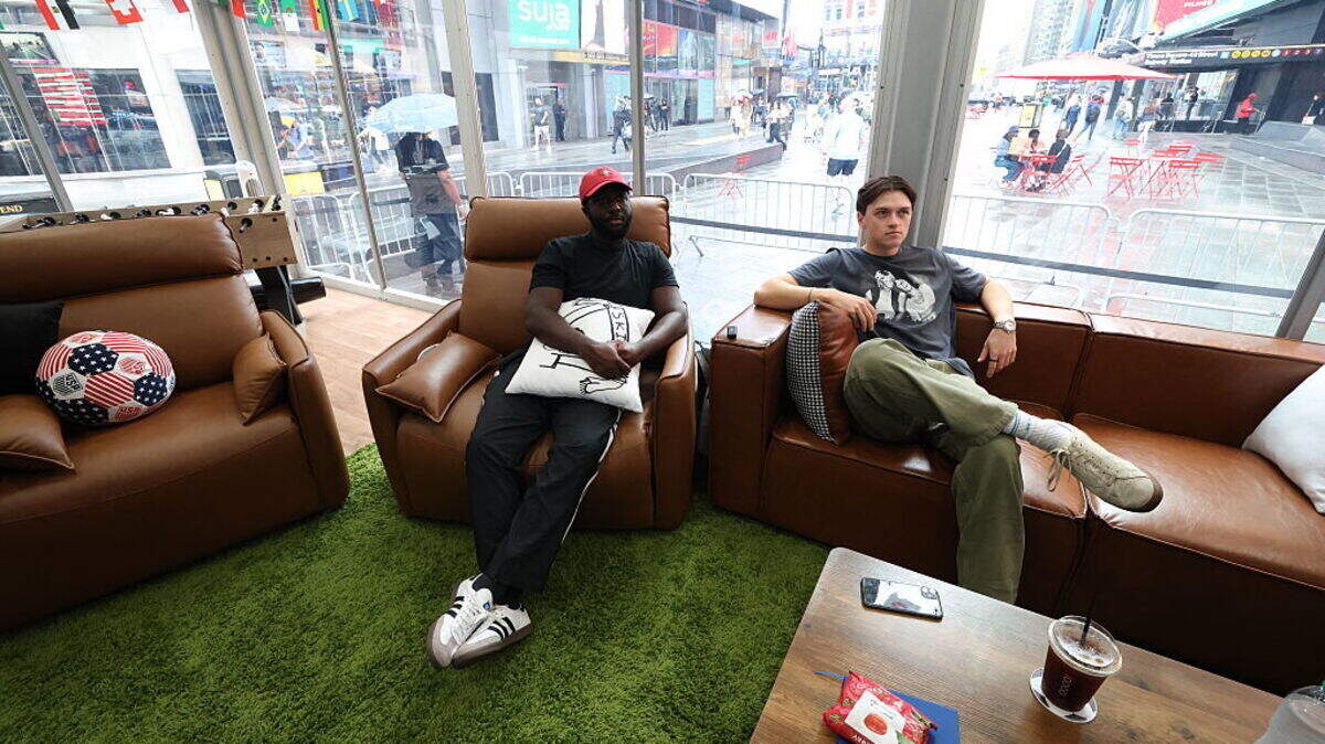 Austin Franklin (derecha) y Kevin Akoto ven el partido de la Copa Mundial entre Portugal y Uzbekistán desde su cubo transparente en Times Square, Nueva York, el 23 de junio de 2026.