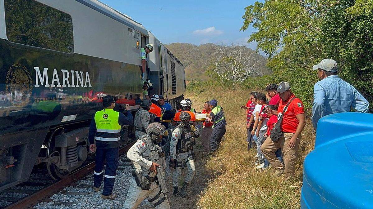 Mexican Army soldiers and Civil Protection members rescue passengers from the Interoceanic train that derailed in Nizanda, Oaxaca state, on the route to Coatzacoalcos, Mexico, on December 28, 2025. At least 20 people were injured on December 28, 2025, after a train crashed in the southern Mexican state of Oaxaca, authorities said. (Photo by Rusvel RASGADO / AFP via Getty Images)