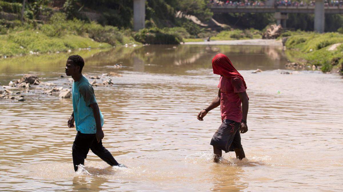 Foto de archivo. Dos haitianos cruzan el río Masacre, la frontera natural entre República Dominicana y Haití. 