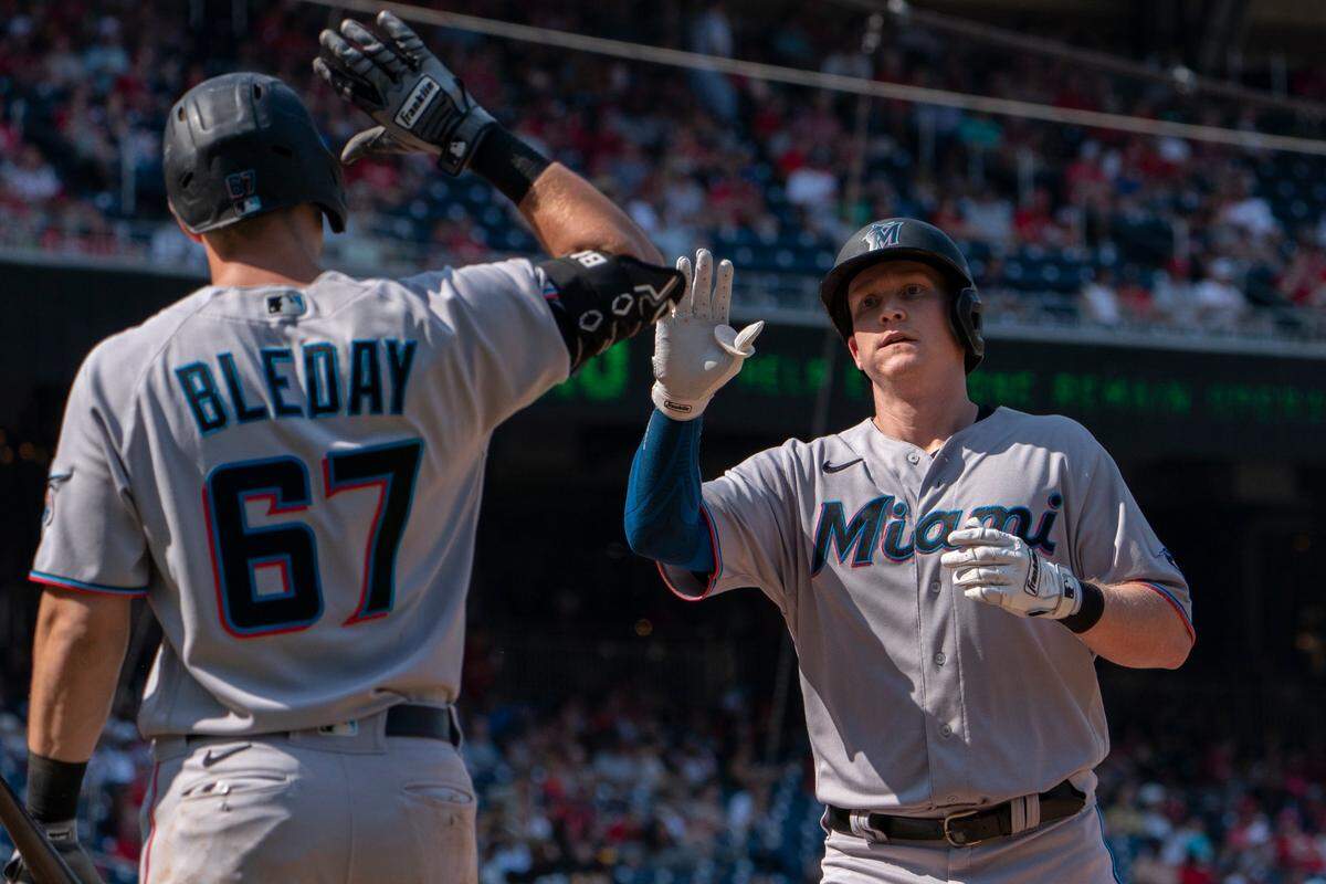 El bateador designado de los Marlins Garrett Cooper (der.) recibe el saludo de JJ Bleday tras pegar un jonrón en el sexto inning del partido ante los Nacionales, celebrado el 18 de septiembre de 2022 en Washington.