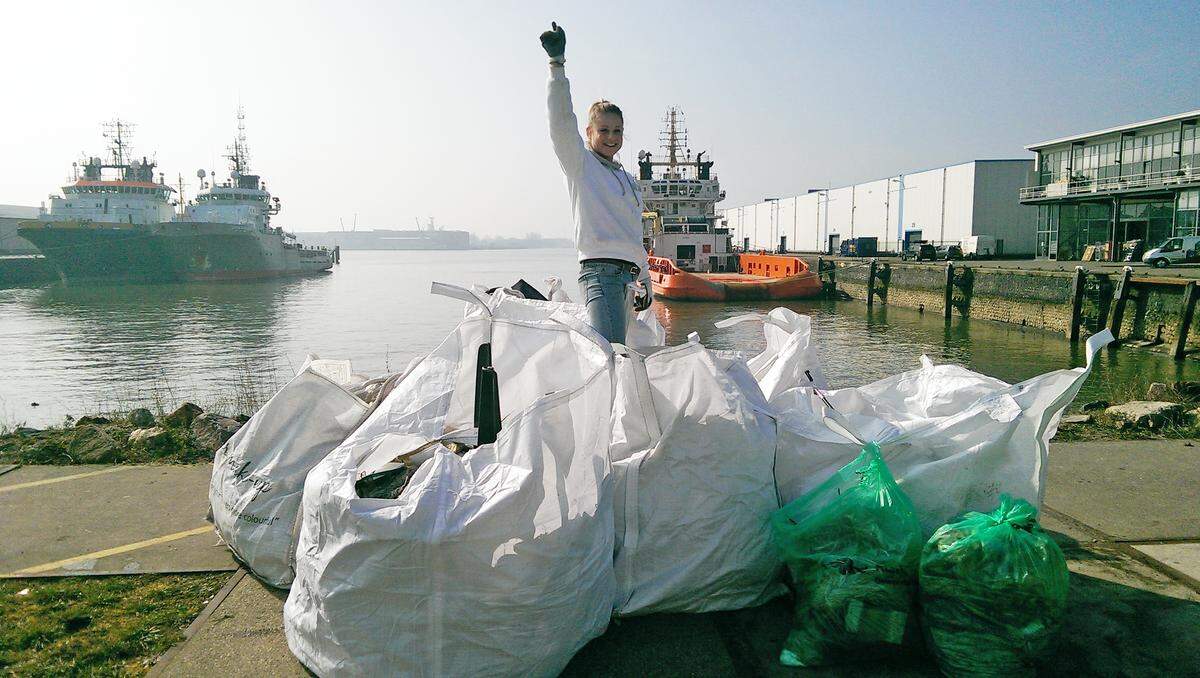 Una voluntaria muestra el grupo de bolsas con materiales de desechos sacados por una de las barcazas en el río Nuevo Mosa, en Róterdam.