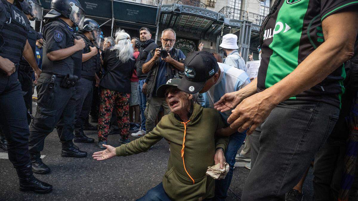 Un jubilado se arrodilla para implorar que no lo golpeen, durante una protesta contra las duras medidas de austeridad del gobierno de Javier Milei, el 12 de marzo de 2025, en Buenos Aires, Argentina. 