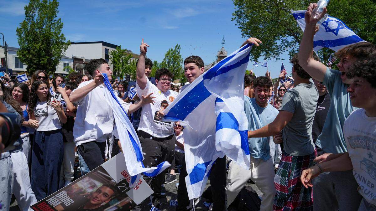 Los participantes aplauden y vierten agua mientras se anuncia que la Cruz Roja obtuvo la custodia del rehén estadounidense-israelí Edan Alexander, el lunes 12 de mayo de 2025, Tenafly, Nueva Jersey.