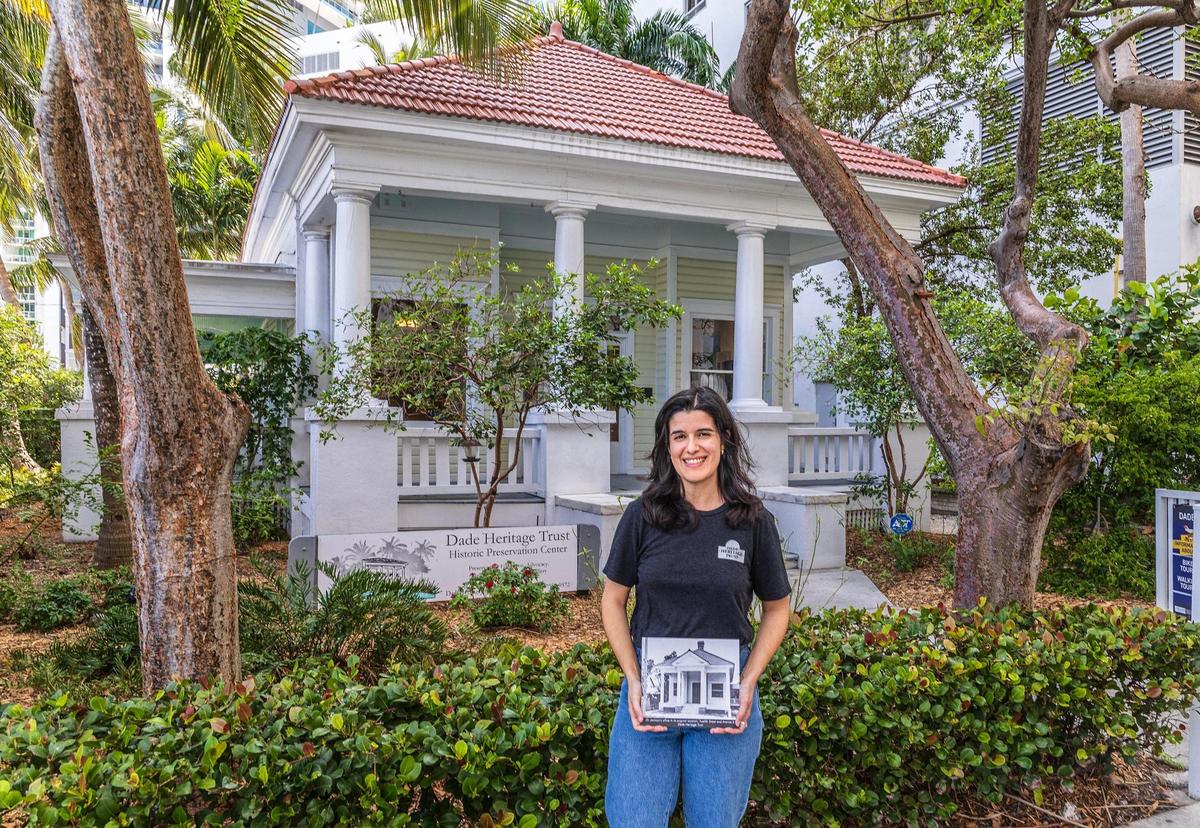 Lucía Meneses, directora de los programas educativos de Dade Heritage Trust, muestra fotos históricas de la oficina del Dr. James Jackson. La casita de madera en el vecindario de Brickell fue incluida en el Registro Nacional de Lugares Históricos en 1975.