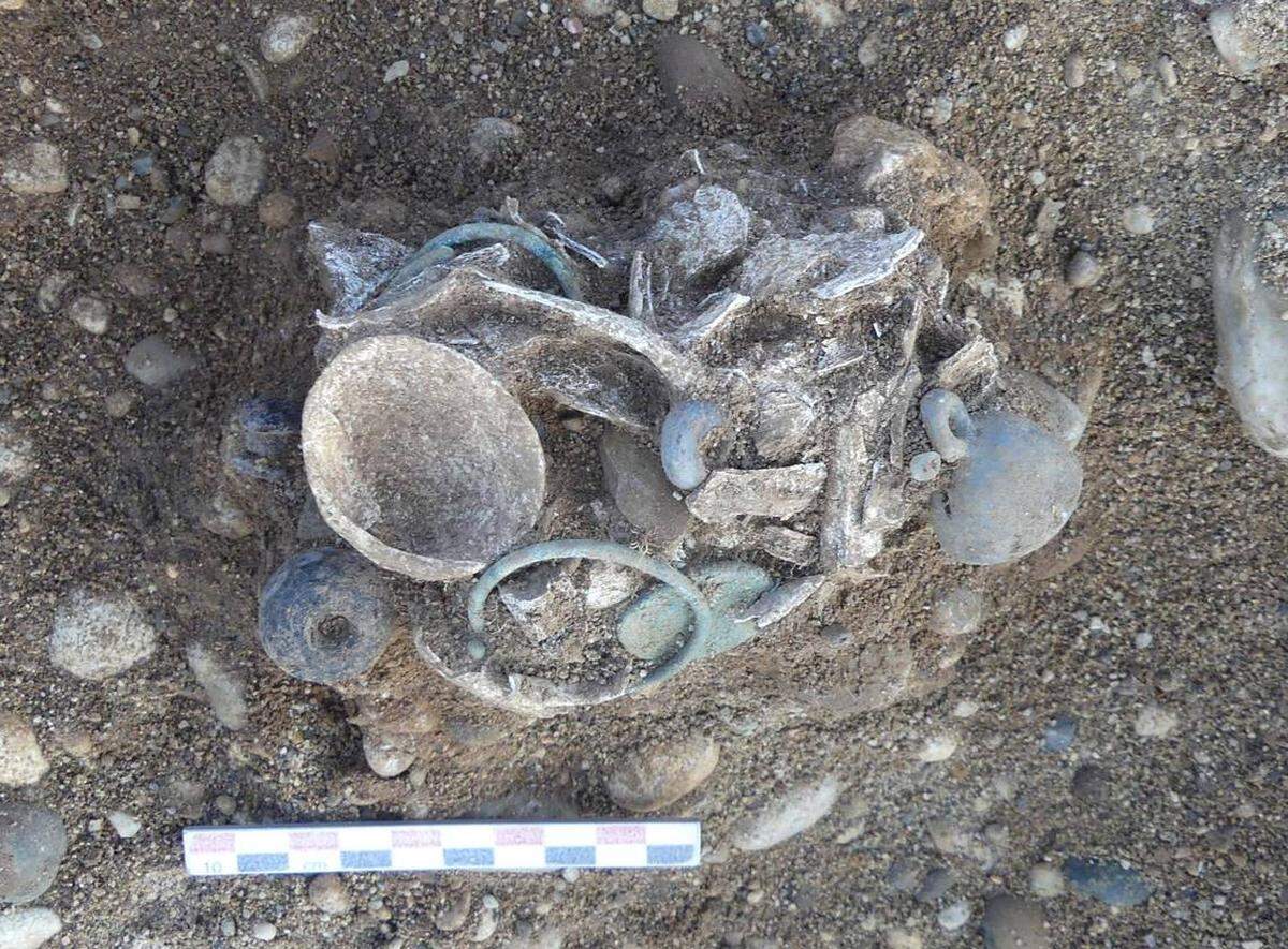 Tumba de un niño enterrado con brazaletes y pendientes de concha. 