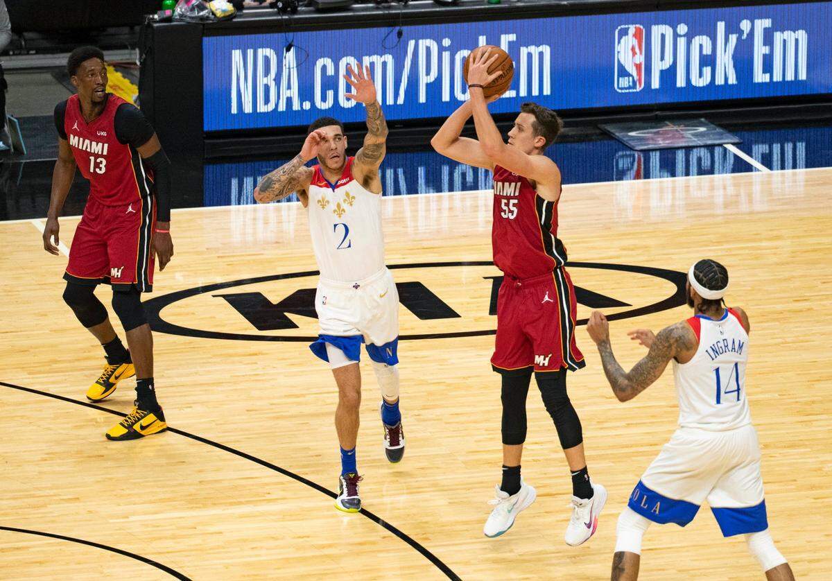 Miami Heat forward Duncan Robinson (55) in the third shots against New Orleans Pelicans guard Lonzo Ball (2) and Pelicans forward Brandon Ingram (14) in the third quarter of a NBA basketball game on Christmas Day at the AmericanAirlines Arena on Friday, December 25, 2020.